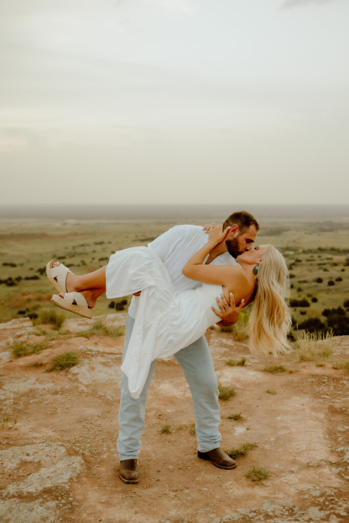 couple dip kissing on top of the mountain at their elopement