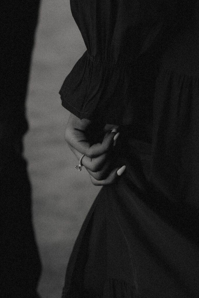 Close-up of a couple’s hands intertwined, with the textured salt flats in the background