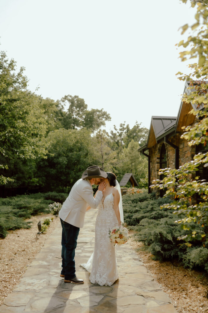 bride and groom stopped on sidewalk of 81 ranch wedding venue rustic wedding venue oklahoma