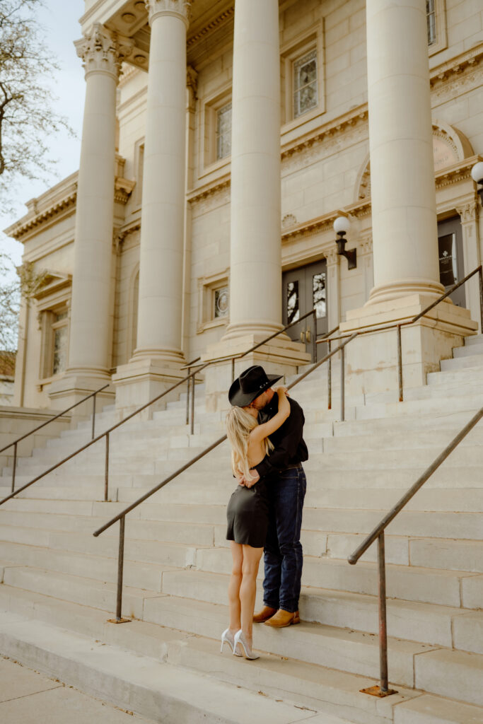 couple kissing on the steps of frontline church at their engagement session documented by oklahoma city photographer