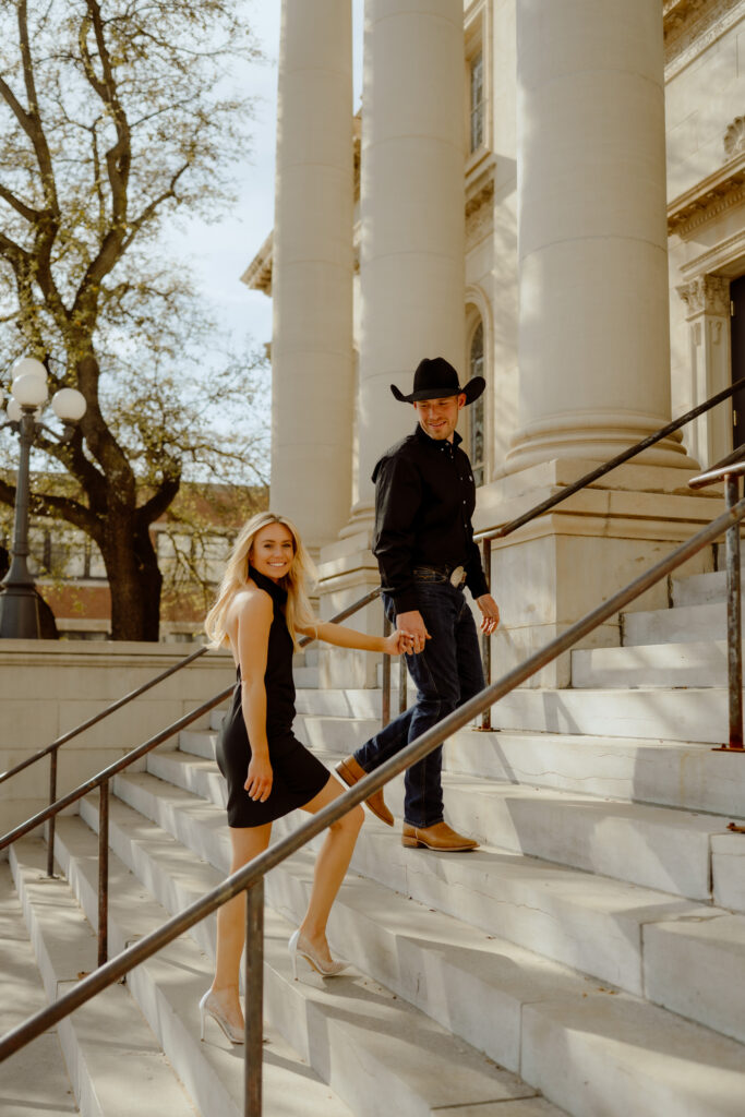 couple walks up the steps while bride looks at the camera of Oklahoma City photographer