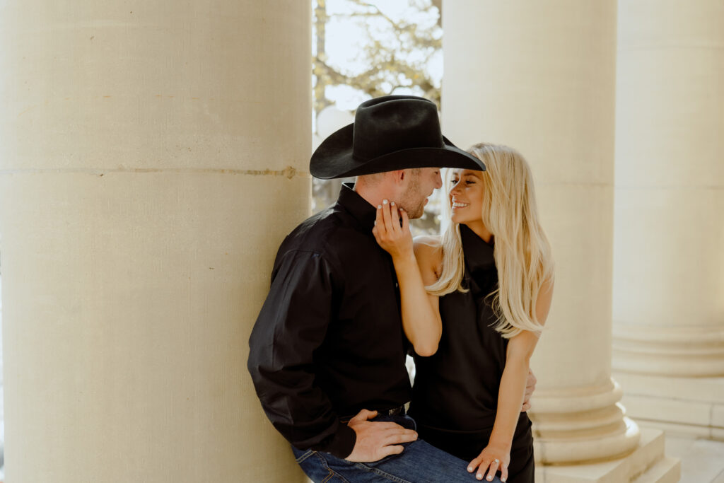 couple smiling at each other at their engagement session documented by oklahoma city photographer