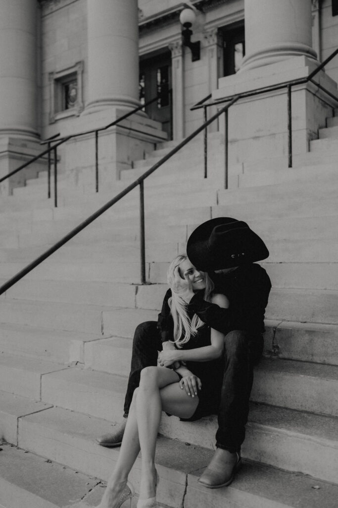 couple sits on the steps laughing together captured by oklahoma city photographer
