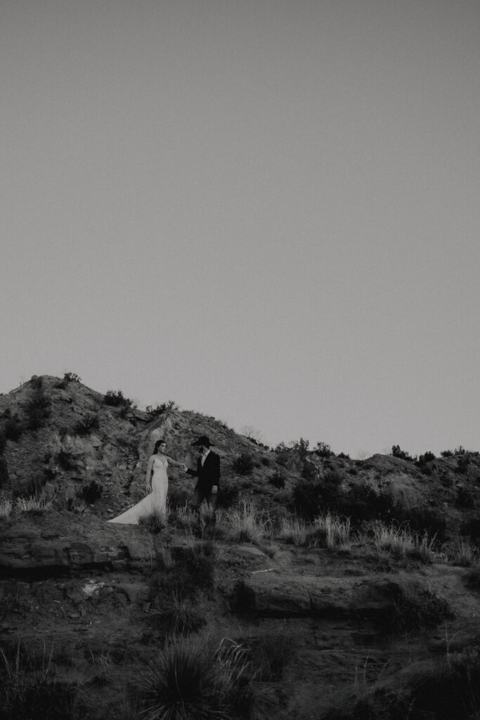 groom leading bride down the canyon