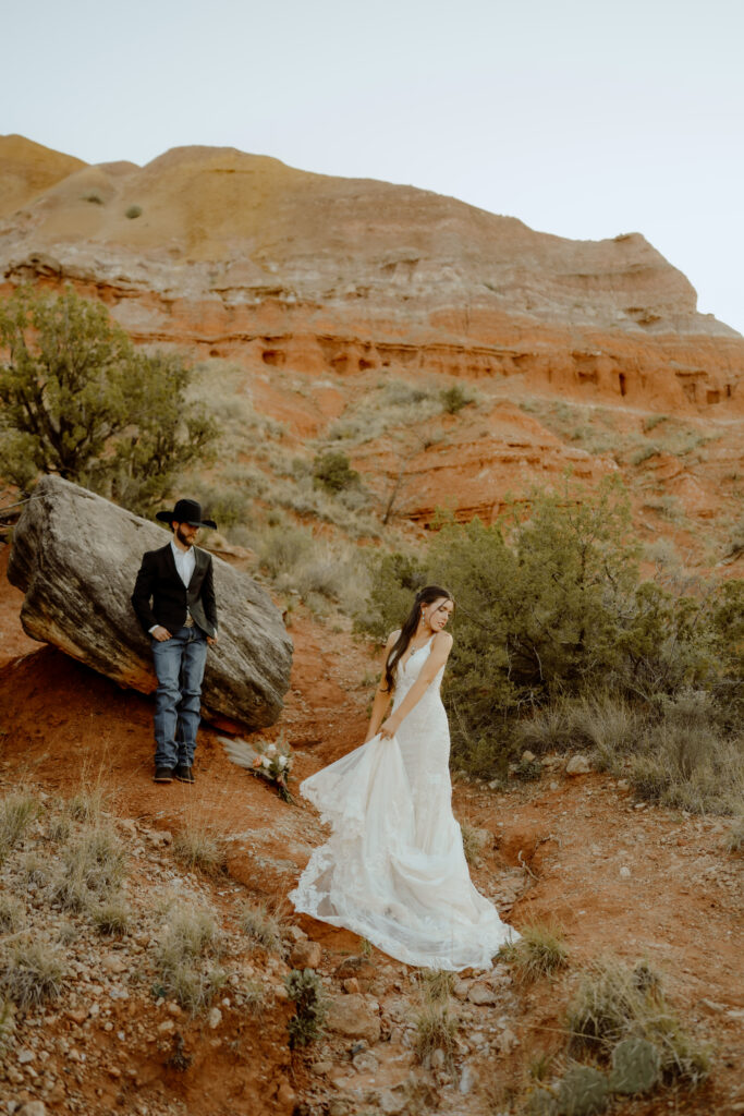 portrait of groom admiring as bride flows her dress