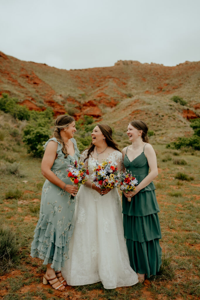 bride and bridesmaids looking at each other lauging