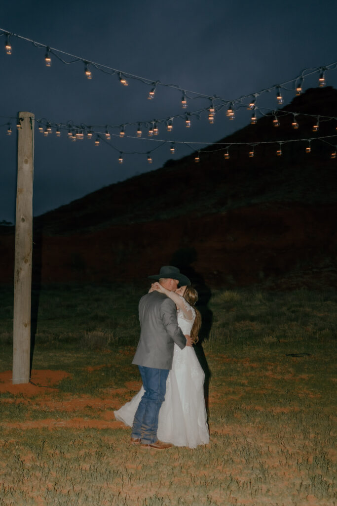 bride and groom first dance under string lights
