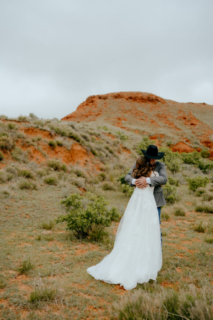 bride and groom share a hug during their first look at their cowboy wedding