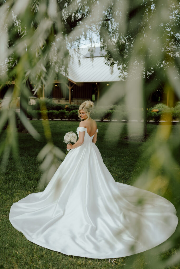 bridal portrait taken through the willows by wedding photographer at the springs wedding venue