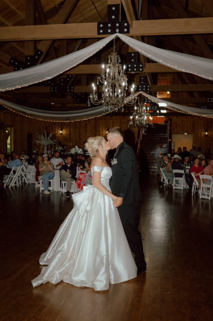 bride and groom kiss during first dance at the springs reception space