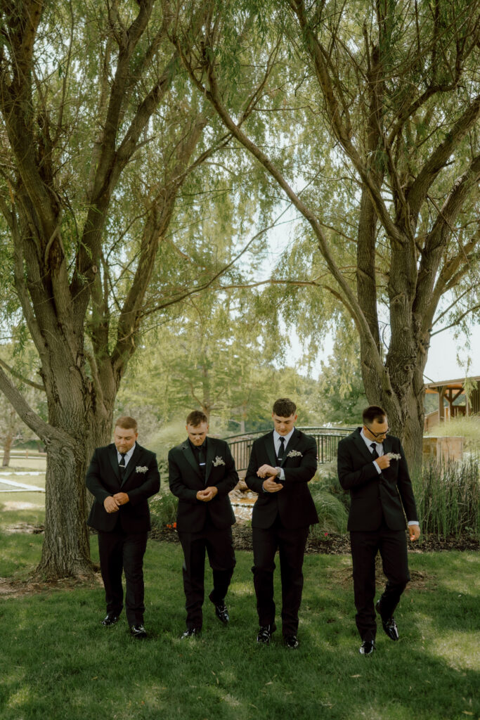 groom and groomsmen walk towards photographer at the springs wedding venue