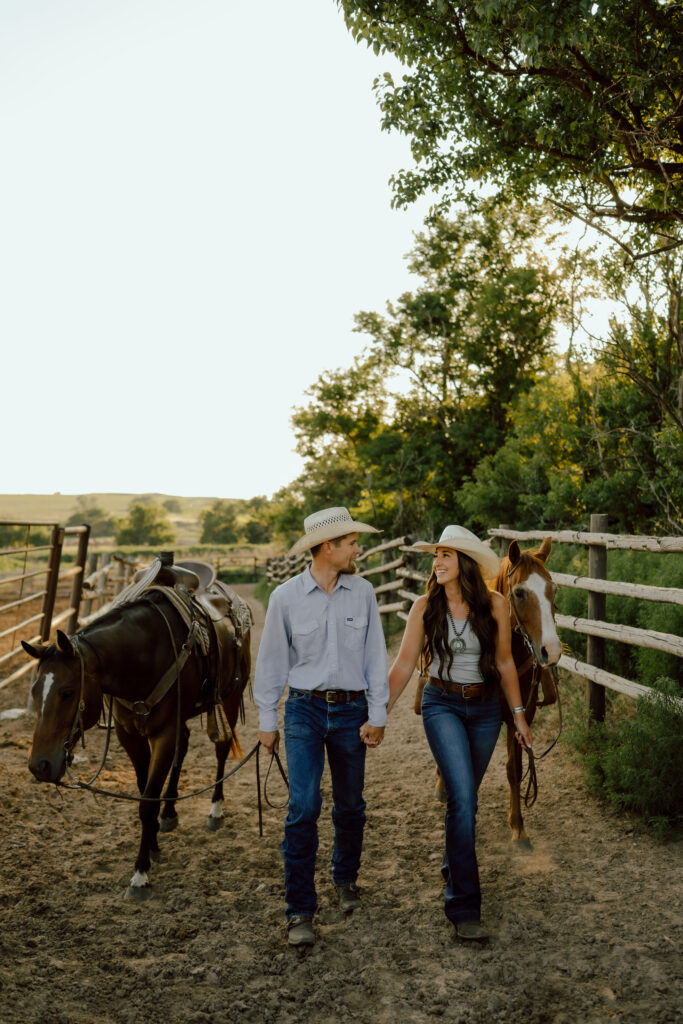 couple leading horses at their western couples photo session