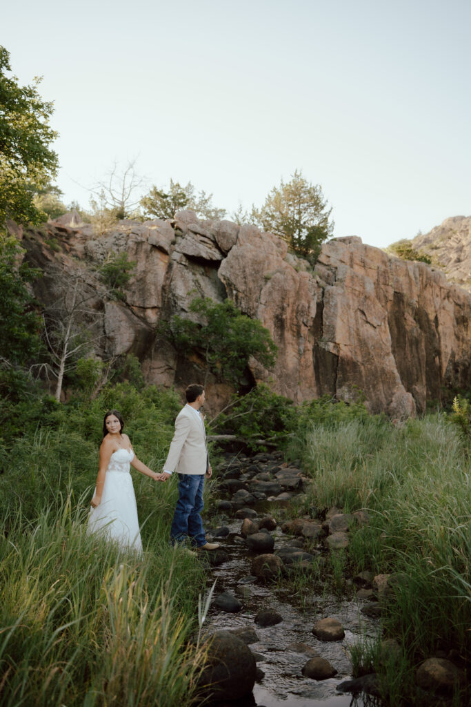 bride and groom walk along the creek at narrows trail