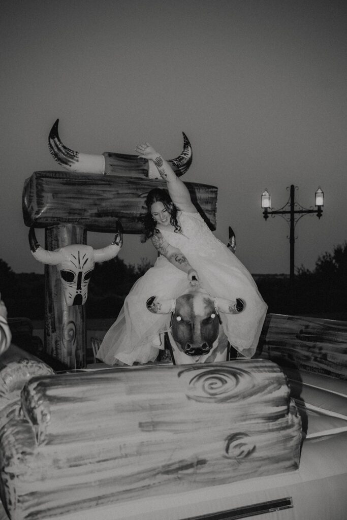 bride riding mechanical bull at western wedding